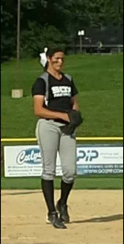 Softball player in team gear on the field at Oil City Stadium area